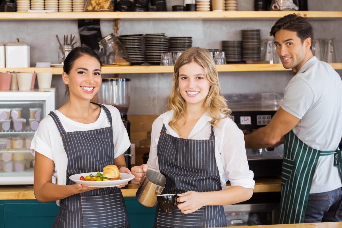 Zwei Frauen und ein Mann arbeiten in einem Gastronomiebetrieb