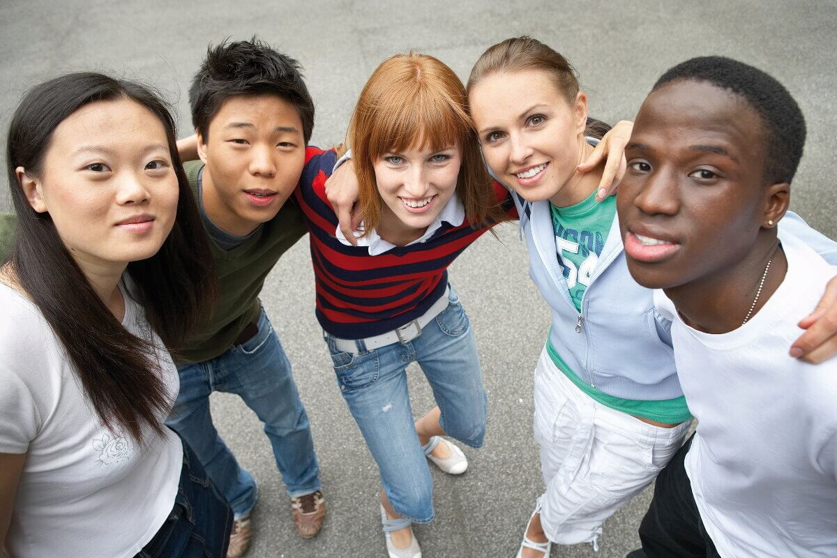 Junge Menschen unterschiedlicher Hautfarbe blicken nach oben