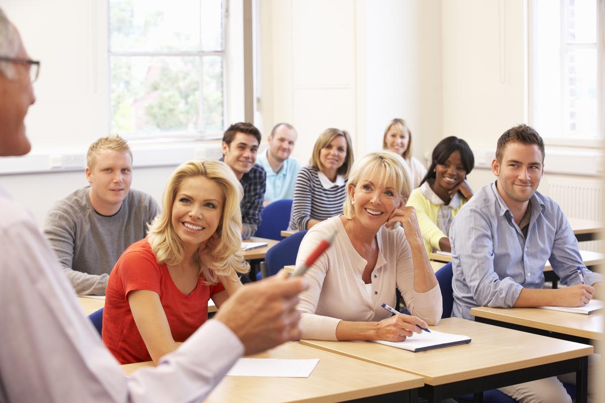 Eine Gruppe Menschen die in einem Unterrichtsraum sitzen