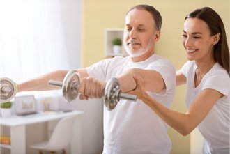 Eine Frau zeigt einem Mann Übungen zur Physiotherapie